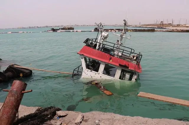 لا يظهر من سفينة غارقة سوى جسر القيادة فوق سطح المياه في ميناء المخا، غداة هجوم شنه الحوثيون على المدينة التي كانت تسيطر عليها الحكومة اليمنية المعترف بها دولياً والمتمركزة في عدن، في 10 أغسطس/آب 2026.