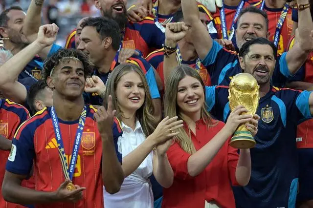 الأميرة صوفيا ترفع كأس العالم وسط احتفالات المنتخب الإسباني بالتتويج بلقب مونديال 2026، وإلى جانبها الأميرة ليونور والمهاجم لامين يامال، عقب الفوز على الأرجنتين في المباراة النهائية على ملعب نيويورك/نيوجيرسي في إيست راذرفورد بالولايات المتحدة، في 19 يوليو/تموز 2026.