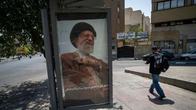 شاب إيراني يمر أمام صورة المرشد الأعلى الراحل آية الله علي خامنئي في طهران، إيران، في 16 يوليو/تموز 2026، وسط تصاعد التوترات بين إيران والولايات المتحدة. 